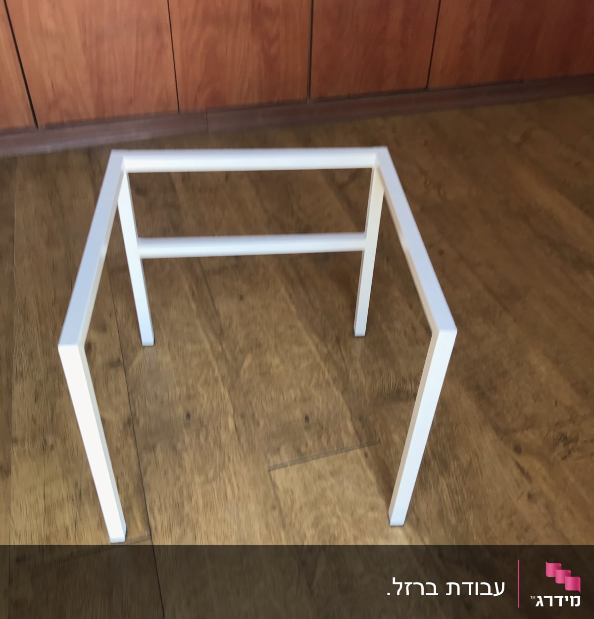 מסגרת מתכת לבנה על רצפת עץ